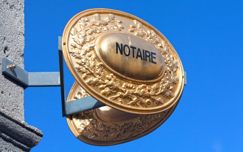 Outdoor sign indicating that a Notaire (french for notary) is practicing inside the building.