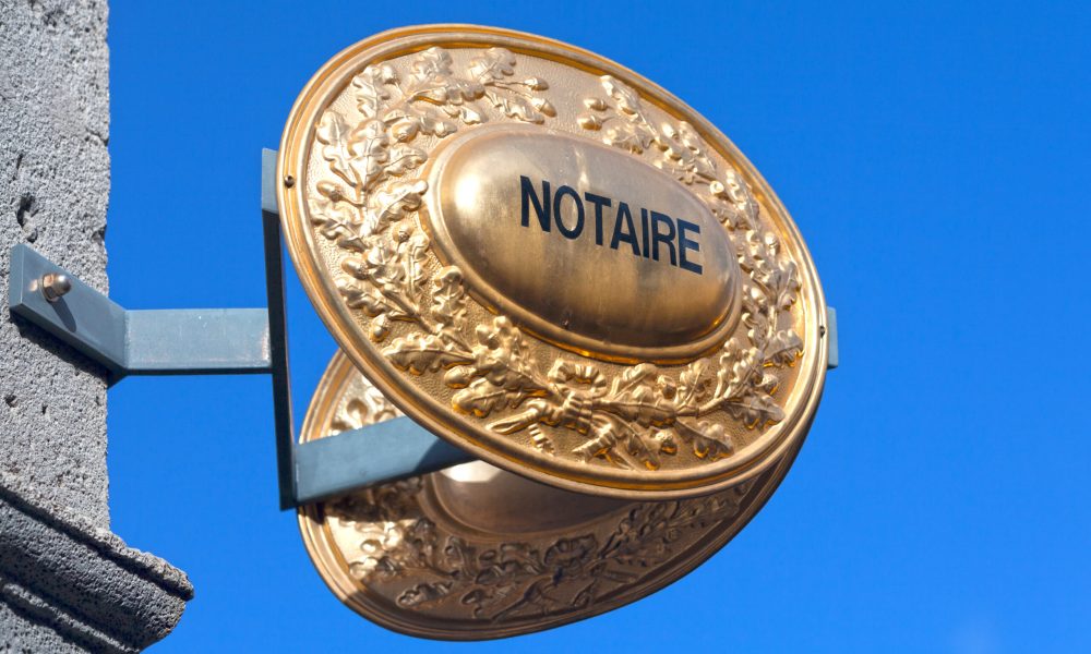 Outdoor sign indicating that a Notaire (french for notary) is practicing inside the building.